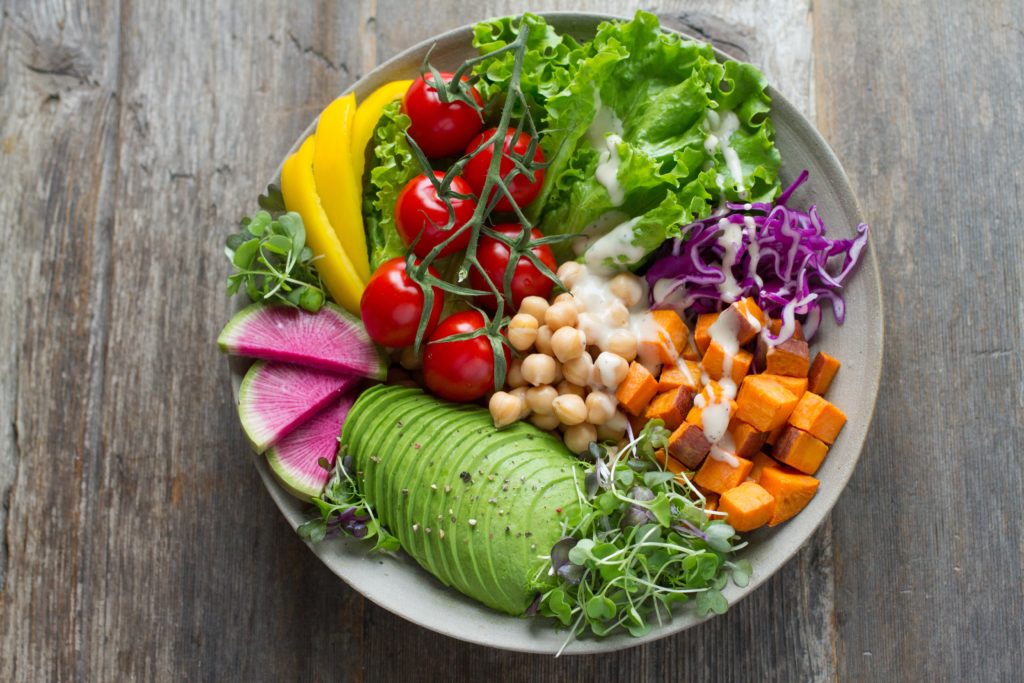 Bol sain avec de la salade, de l'avocat, des tomates et de l'oignon