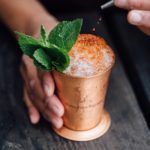 Cocktail servit par un barman dans un verre avec de la menthe et de la glace pilée