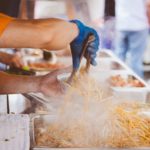 personne servant des nouilles sautés dans un food truck